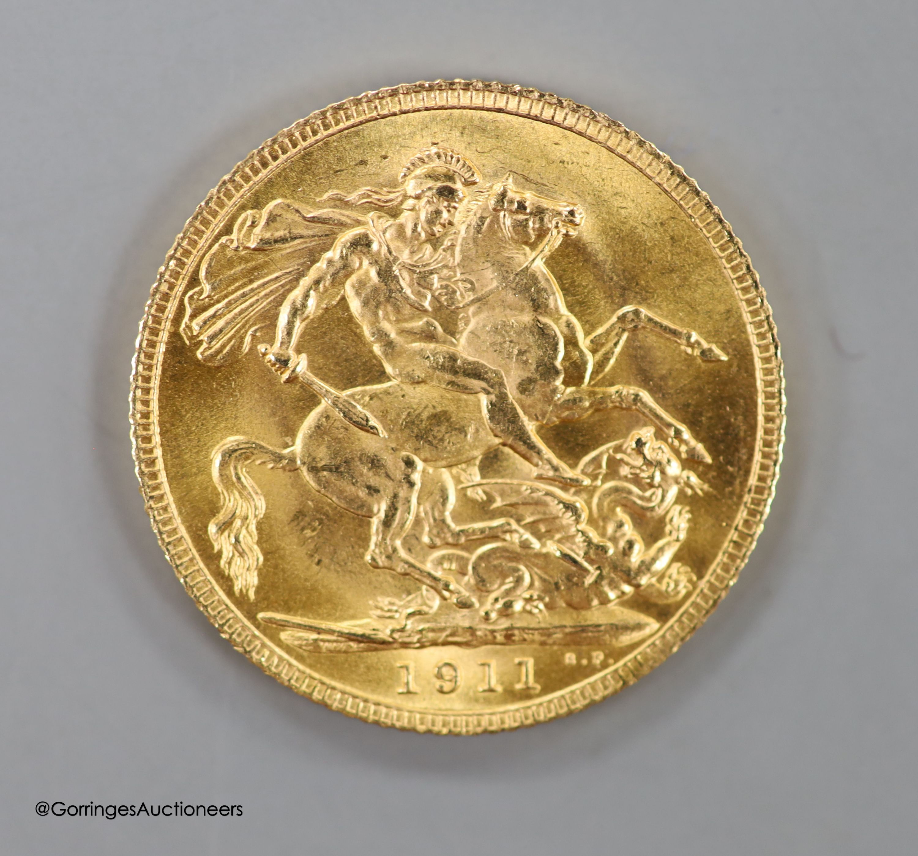 A 9ct gold sovereign case, with engraved monogram, 30mm, gross weight 15.6 grams, containing a George V 1911 gold sovereign